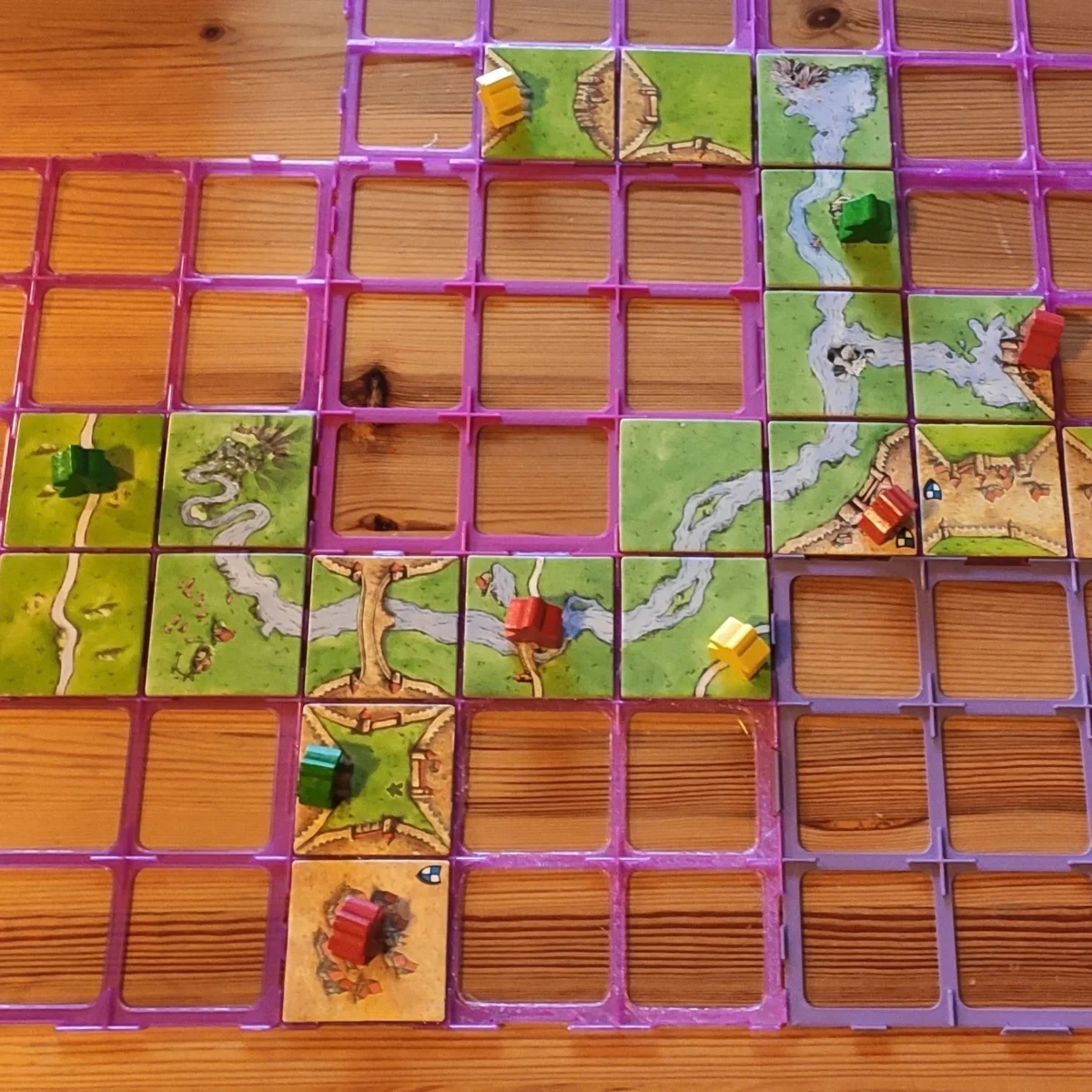 carcassonne-paloja aseteltuna, pääosan kuvasta täyttää eriväriset ruudukot, joihin mahtuu pelilaatta