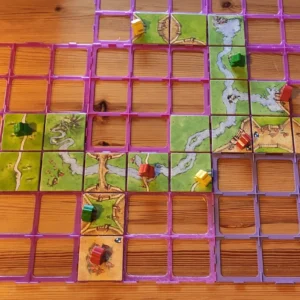 carcassonne-paloja aseteltuna, pääosan kuvasta täyttää eriväriset ruudukot, joihin mahtuu pelilaatta