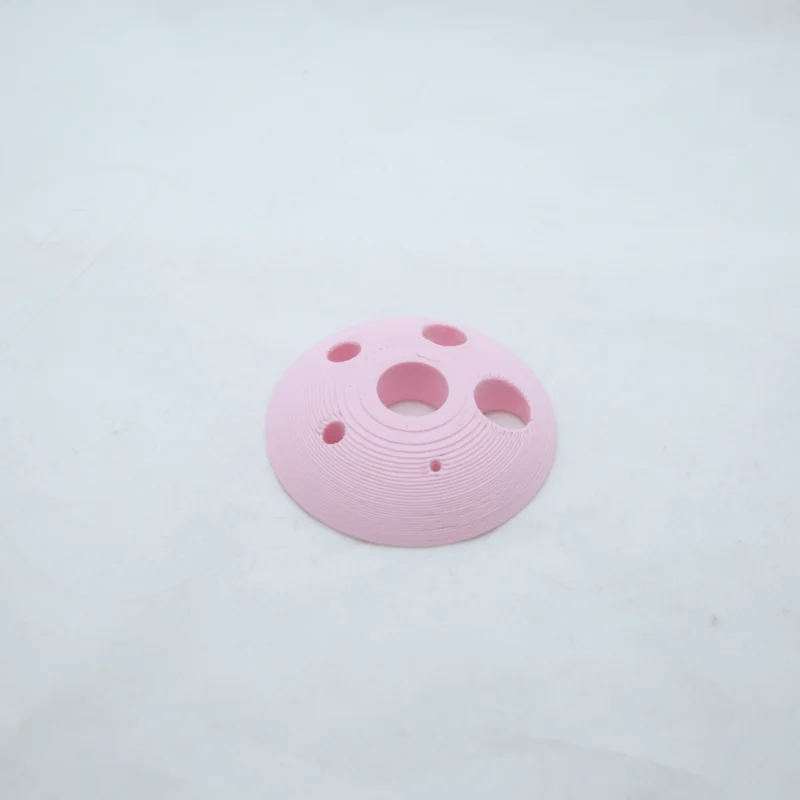 pyöreä kiekko joka on melkein puolipallon muotoinen. Kiekossa on 6 eri kokoista reikää.