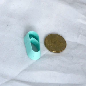 vasemmalla flipflopin muotoinen askartelumassaleikkuri, sen oikealla puolella 20 sentin kolikko mittakaavana