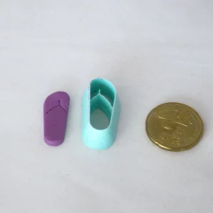 tavallinen flipflop leikattuna askartelumassasta, vasemmassa reunassa. keskellä leikkuri ja oikeassa reunassa 20snt kolikko